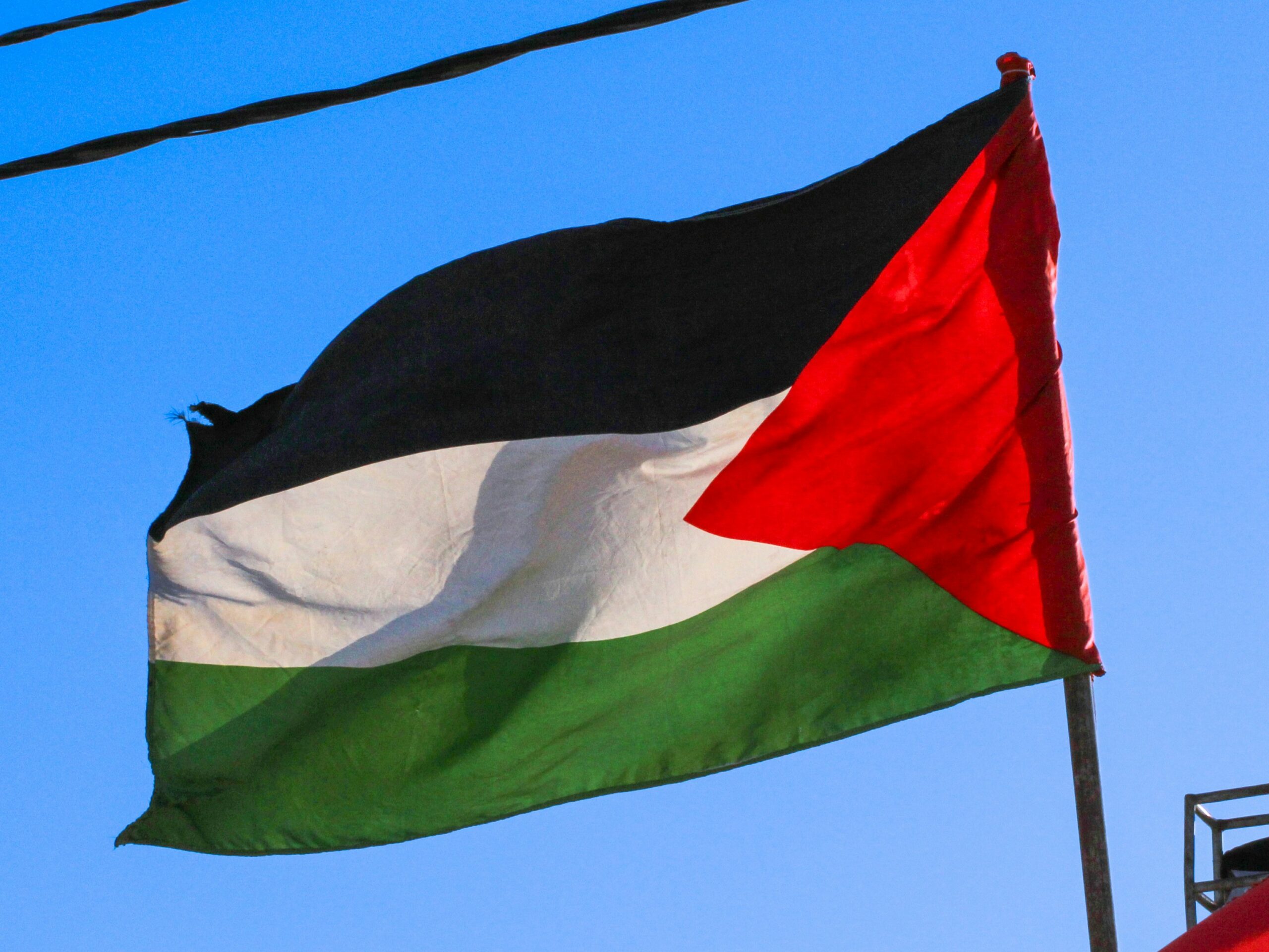 Palestinian flag with blue sky behind it
